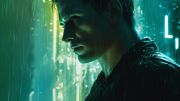 Close up of Kovacs in the rain with a neaon light behind him illuminating his face in the night